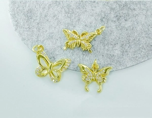 Detailed close-up of three 18K gold plated butterfly pendants with zircon inlay stones