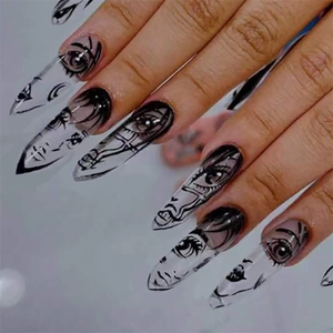 Uñas postizas stiletto largas con graffiti de caras negras sobre base transparente artística