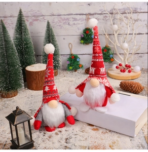 Close-up of knit Christmas gnomes set with deer patterns on white book and winter decor