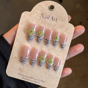 Long almond French press-on nails with pink base, black zebra stripes and 3D floral accents