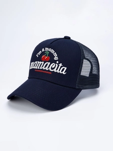 Detail of navy trucker hat featuring embroidered mamacita text and red cherry design
