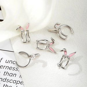 Silver rabbit ear ear cuffs with pink accents shown on model and display card