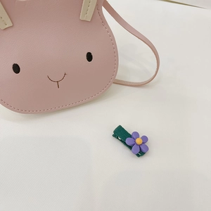 Detail of pink rabbit coin purse and floral hair clip for toddler girls' accessories