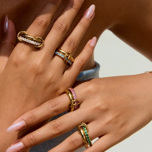 Close-up of interconnected gold rings with colorful cubic zirconia pavé detailing
