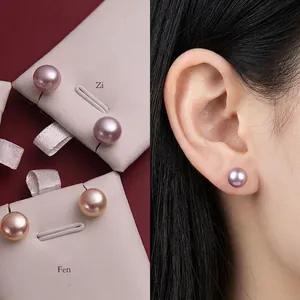 Detail of natural freshwater pearl studs in purple and pink tones with elegant luster