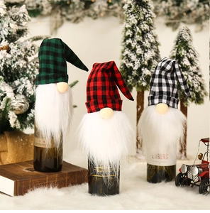 Three Christmas gnome wine bottle covers with red, green and grey plaid hats in a cozy scene