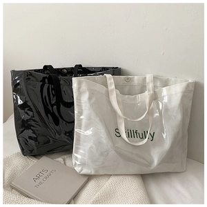 Detail view of large transparent jelly tote bags with wide handles and Skillfully text