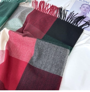 Detail shot of checkered cashmere-feel scarf featuring fringe edges and plaid pattern