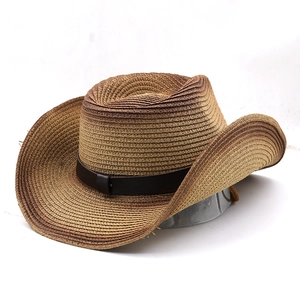 Detail of tan gradient straw cowboy hat featuring wide brim and brown leather band