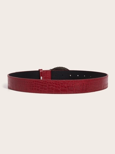 Close-up of red crocodile pattern leather belt with polished silver pin buckle detail