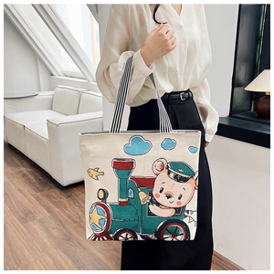 Lifestyle view of canvas tote bag with cartoon bear print and striped handles