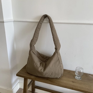 Detailed view of khaki quilted puffer tote bag showing soft padded texture and zipper