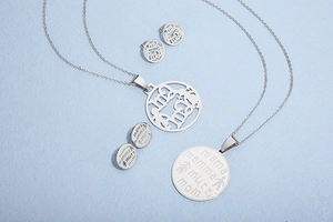 Detailed view of silver titanium steel necklace and earrings set with mama engravings