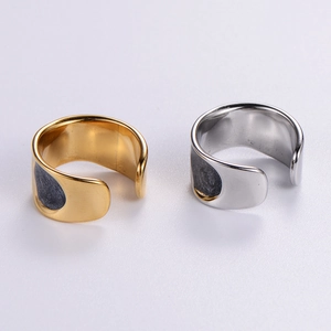 Detail of irregular textured open rings in gold and silver finish with black matte inlay