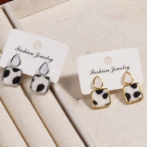 Detail of square horsehair leopard print earrings with gold and silver waterdrop studs