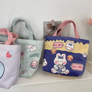 Detailed view of three cute cartoon canvas tote bags with rabbit prints on white shelves