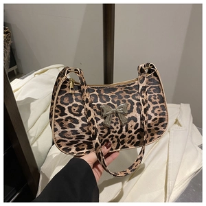 Close-up of leopard print baguette bag featuring a silver metal bow accent and zipper