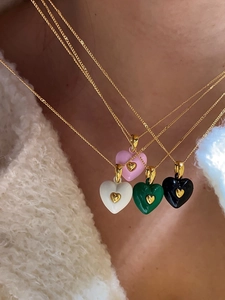 Close-up of four colorful heart pendants with gold mini-hearts on gold necklaces