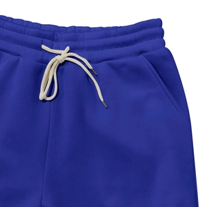 Close-up of elastic waistband with off-white drawstring on royal blue fleece sweatpants
