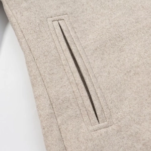 Minimalist beige wool blend overcoat featuring a single-breasted design and welt pocket