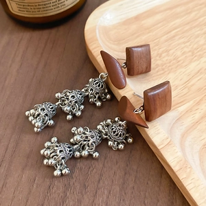 Détail des clous carrés en bois avec pompons à clochettes Jhumka argentées à trois niveaux