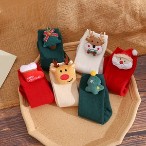 Close-up of six pairs of Christmas cotton socks with plush cartoon 3D decorations