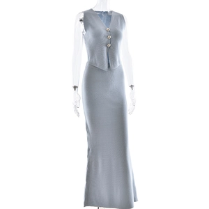 Detail of light blue knitted two-piece set featuring vest with decorative buttons and maxi skirt