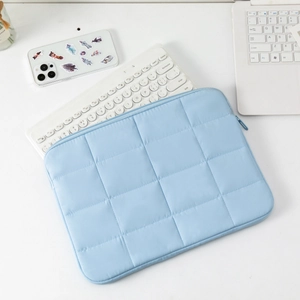 Detail of light blue quilted 14 inch laptop sleeve with premium metal zipper and padding