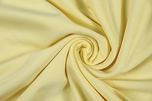 Macro shot of pale yellow ribbed knit fabric texture showing softness and drape