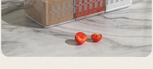 Close-up of transparent plastic spice boxes with colorful seasonings on a marble countertop