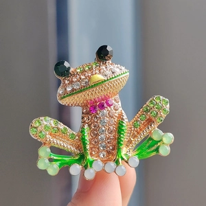 Detail of frog brooch with colorful crystals and green enamel on a gold-plated base