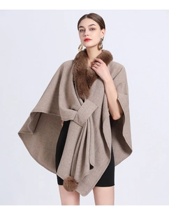 Close-up of camel knit shawl featuring faux fur collar and decorative pom-pom tassels