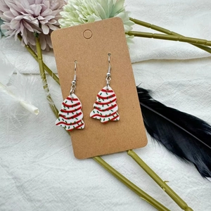 Détail de boucles d'oreilles sapin de Noël en acrylique avec rayures colorées sur carte