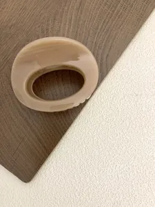 Detail of oval milk tea brown hair claw clip with a glossy finish and minimalist design