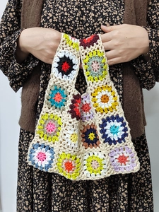 Close-up of handmade crochet tote bag with colorful multi-color floral square patterns