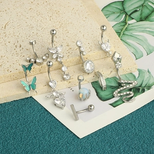 Detailed collection of silver belly rings with butterfly, snake, and heart zircon charms
