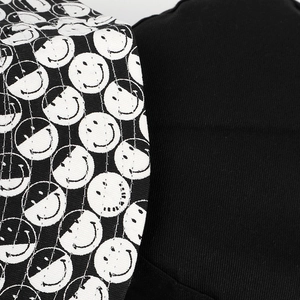 Détail macro du chapeau bob noir avec imprimé smiley et coutures en toile de coton
