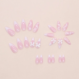 Detailed flat lay of almond-shaped press-on nails with French tips and 3D ribbon bows