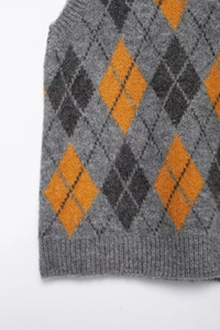 Detail of ribbed hem on diamond argyle knitted vest in grey and orange shades