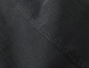 Macro shot of precise stitching and premium texture on black poplin fabric