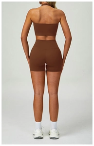 Back view of a woman in dark brown high-waisted yoga shorts and matching sports bra