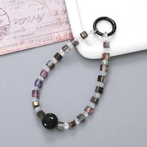 Detail of colorful square beads and a black rhinestone charm on a phone lanyard strap