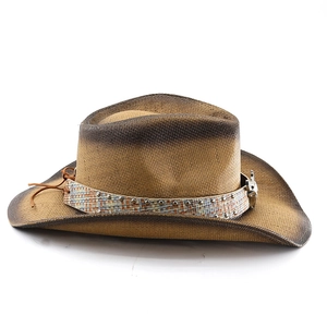 Detail of straw cowboy hat featuring metallic studs and silver skull ornament decoration