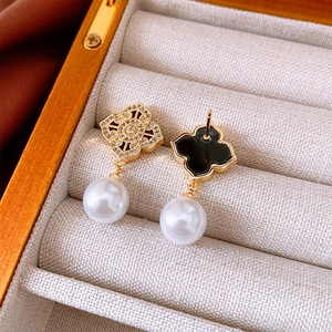 Macro shot of vintage style earrings with zirconia hollow gold pattern and white pearls