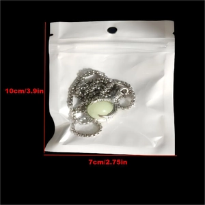 Detailed view of dragon claw pendant with glowing bead in 10x7cm plastic packaging