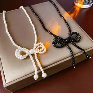 Elegant beaded bow necklace with pearl fringe tassels in black and white finish