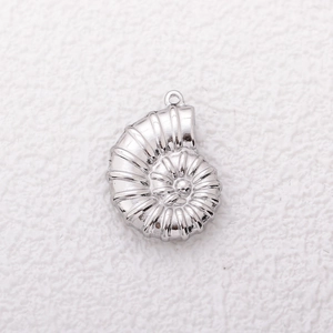Macro shot of silver stainless steel nautilus shell pendant with detailed metallic texture