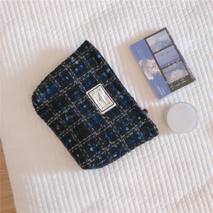 Detail of navy blue tweed cosmetic bag showing woven texture and TIME TO PARTY label