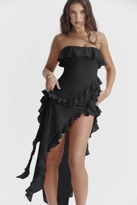 Détail de la robe noire à épaules dénudées avec volants superposés et ourlet asymétrique