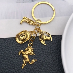 Detail of golden western cowboy keychain with hat, boot and horse charms on leather